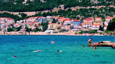 NEUM, BOSNIA VE HERZEGOVINA, Temmuz 03: 2020: İnsanlar Bosna-Hersek 'in Neum kentinde güneşli bir yaz günü Adriyatik Denizi' nde banyo yapıyorlar.