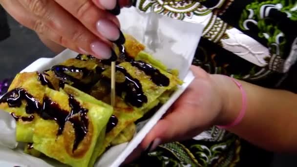 Una Mujer Está Comiendo Panqueques Plátano Una Escena Las Calles — Vídeos de Stock