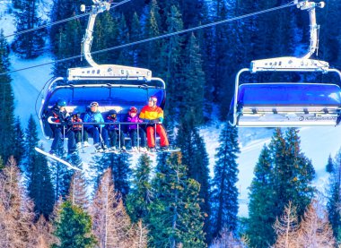 NASSFELD, AUSTRIA, Ocak 06 2019: Avusturya 'nın Nassfeld kentindeki kayak pistinin tepesine giderken kayak asansörü kabininde kayakçılar.