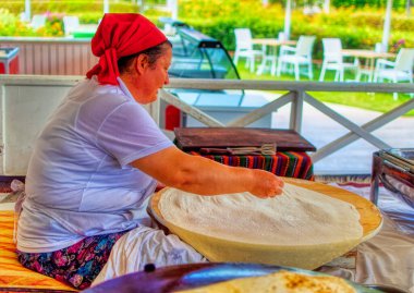 ANTALYA, TURKEY, 03 Ağustos 2019: Türkiye 'nin Antalya kentinde gözleme olarak bilinen geleneksel hamur işlerini yapan bir Türk kadın.
