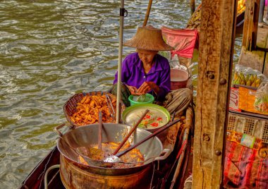 Samut Songkhram Eyaleti, Tayland, 01 Ocak 2020: Tayland 'da Samut Songkhram Eyaleti' nde yüzen markette yiyecek satan yaşlı bir kadın.