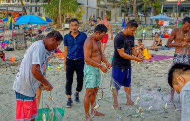 PHUKET, THAILAND, Ocak 03 2020: Yerel balıkçılar Tayland 'ın Phuket plajındaki ağdan balık avlıyorlar.