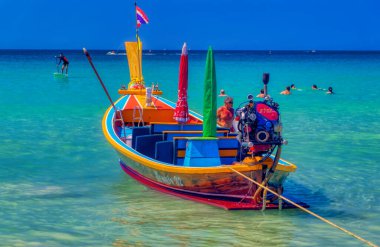 PHUKET, THAILAND, Ocak 04 2020: Uzun kuyruklu tekneler Phuket, Tayland 'daki güneşli kış gününde sığ kumsal sularına yanaştı