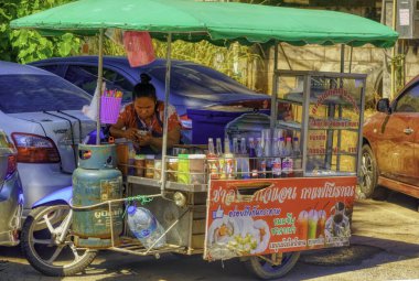 PHUKET, THAILAND, Ocak 04 2020: Genç bir kadın Phuket, Tayland 'daki popüler turistik tatil beldesinde küçük bir cep telefonu dükkanında otururken cep telefonuna bakıyor.