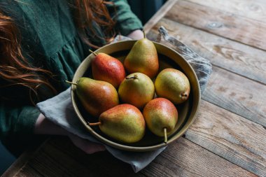 Taze armut hasadı olan bir tabak ahşap bir masaya konur..