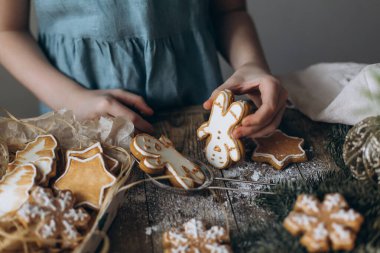 Çocukların elleri masada zencefilli ekmeği oynuyor ladin dalları ve oyuncakların Noel süslemeleri arasında.