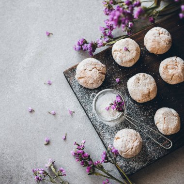 Tahtada toz şekerli kurabiyelerin içinde badem ezmesi ve leylak rengi cilt bakımı..