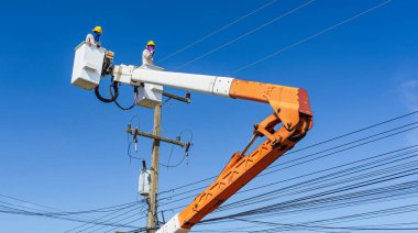 Elektrikçilerin bakımı hidrolik kovada transformatörle yüksek voltajlı elektrikle çalışır.
