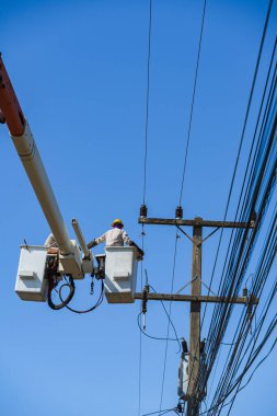 Elektrikçilerin bakımı hidrolik kovada transformatörle yüksek voltajlı elektrikle çalışır.