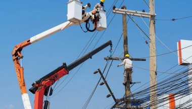 Elektrikçiler yüksek gerilim sistemine ekipman yüklüyorlar.