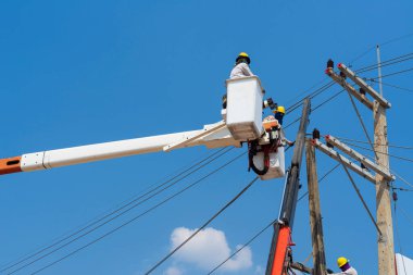 Elektrikçiler yüksek gerilim sistemine ekipman yüklüyorlar.