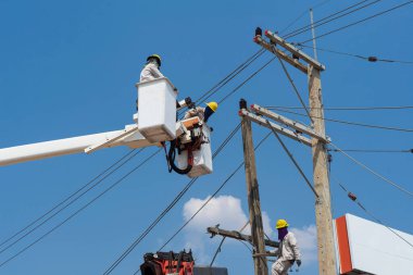 Elektrikçiler yüksek gerilim sistemine ekipman yüklüyorlar.