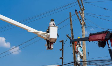 Elektrikçiler yüksek gerilim sistemine ekipman yüklüyorlar.
