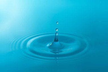 Yakın plan mavi su damlaları beyaz arkaplanda izole edildi.