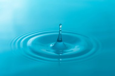 Yakın plan mavi su damlaları beyaz arkaplanda izole edildi.