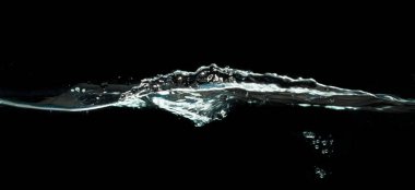 Su sıçraması koyu siyah arkaplanda izole.