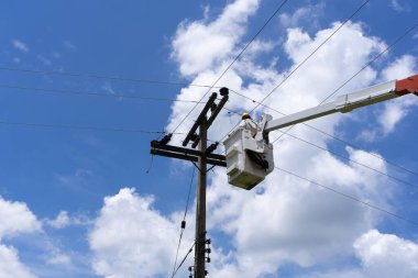 Mühendis ya da elektrikçi kova üzerinde çalışıyor. Yüksek voltajlı iletim hatlarını onarmak için..
