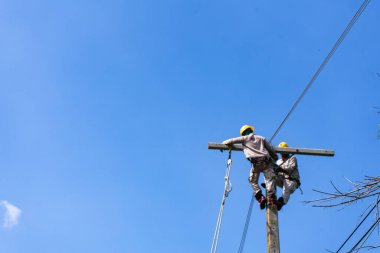 Odak dışı elektrikçi veya mühendis bir elektrik direği ve yüksek voltaj sisteminde çalışıyor..