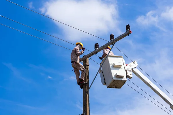 electrician people work installation of high voltage on pole. Engineers working with high voltage hazards