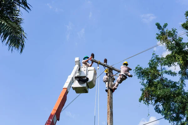 電気技師または技術者は メンテナンスのためのパワーポストと高電圧システムに取り組んでいます 電気工はバケツの中で働く — ストック写真