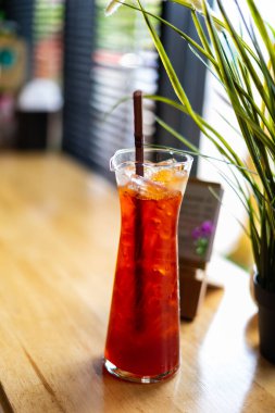 Egzotik bir bardakta, ahşap bir arka plandaki kafede serin içecekler..