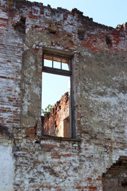 Picturesque boş windows mavi gökyüzünde eski bir konak mahveder. Terk edilmiş bir yer. Geçmişin tarihi anıt. Doğa İnşaat medeniyetin yakalar. Binanın içinde vahşi bitkiler büyümek