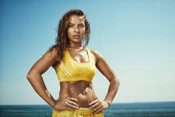 Gökyüzü arka planında çalıştıktan sonra güçlü bir bayan atlet. Açık hava fitness eğitimi
