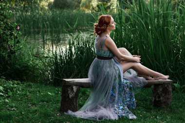 Ormanda uzun elbiseli güzel bir kız.