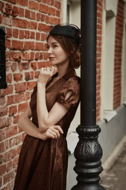 Güzel bir kız, kahverengi bir elbise giyiyor.