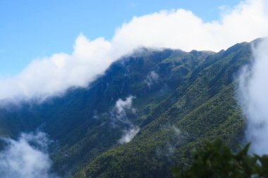 Bulutların üstündeki dağın tepesinden görüntü