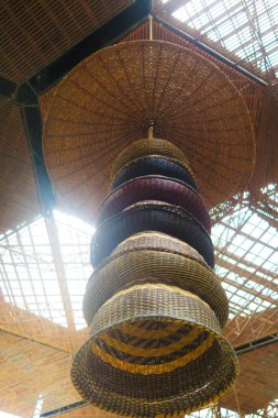 farklı renklerde hasır sepetler örülmüş tavanda asılı