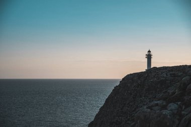 Formentera 'da gün batımında bir uçurumda deniz feneri.