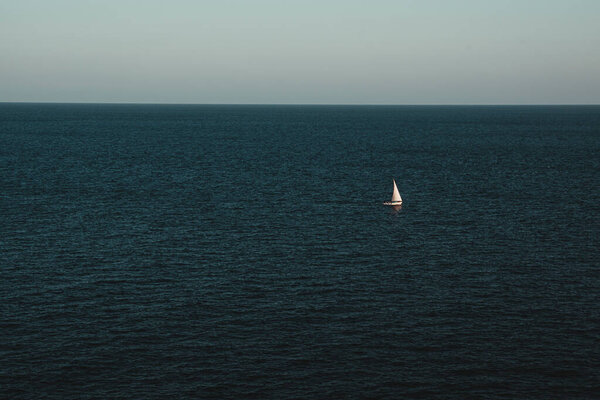 White sailing boat against sea horizon