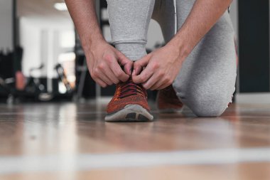 Spor ayakkabı bağcıklarını bağlayan çocuk