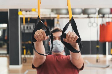 Spor salonundaki jimnastikçi çocuk kasnağı çekiyor.