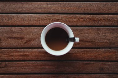 Bir fincan kahve, manzaralı ve berrak gökyüzü.