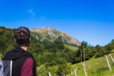 Genç yürüyüşçü dağların ve güzel manzaranın tadını çıkarıyor..