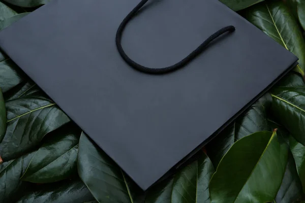 葉の上に黒いマットの紙袋のクローズアップ — ストック写真