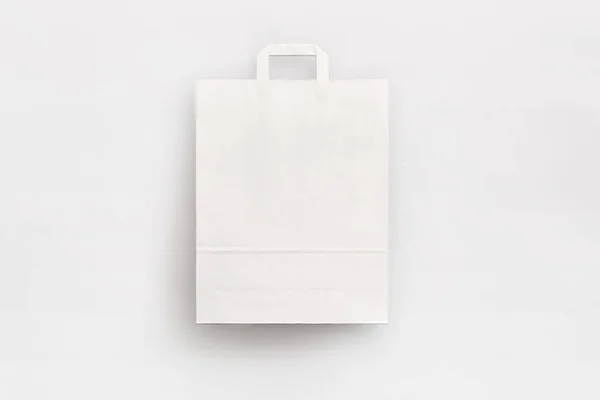 フラットハンドル付きミディアムホワイトの紙袋 — ストック写真