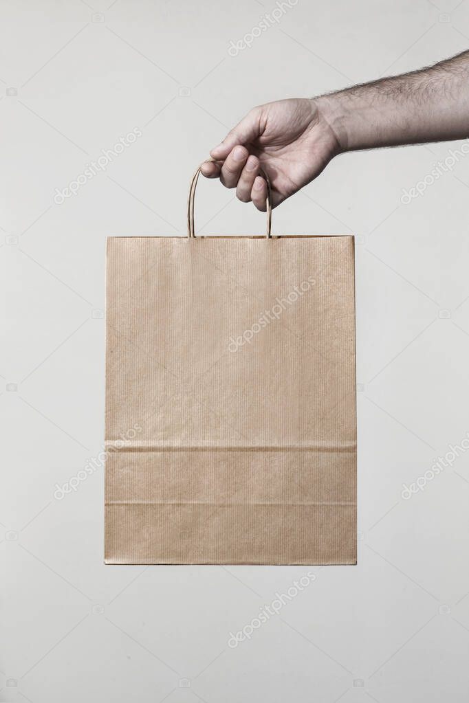 Brown take away paper bag with hand showcasing it