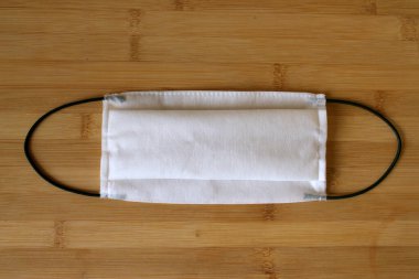 Coronavirus tıbbi maskesi. Ahşap arka planda koruyucu giysi.