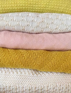 Aydınlık gölgelerde düzgünce katlanmış farklı kumaş türleri.