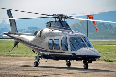 Bulutlu gökyüzünün altında helikopter hazır.