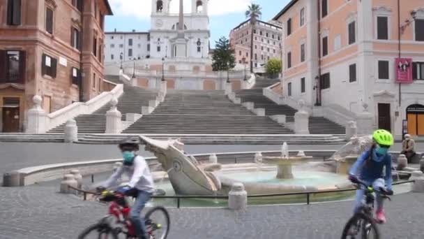 Рим Apt 7 2020, Два молодых мальчика с велосипедом на пустынной площади в связи с covid-19 — стоковое видео
