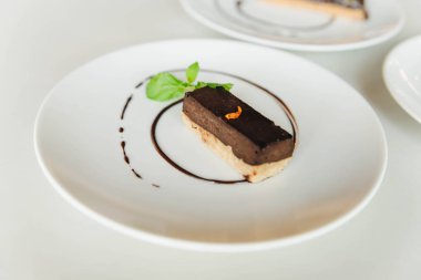 nane ile tatlı çikolata parçası beyaz bir masada bırakır