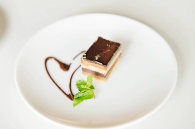 nane ile tatlı çikolata parçası beyaz bir masada bırakır