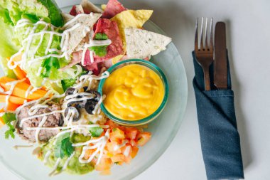  salata ve sos büyük bir plaka üzerinde organik çiplerle