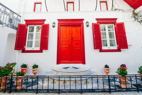 Frente de casa con ventanas rojas en la isla mykonos en Grecia — Foto de Stock