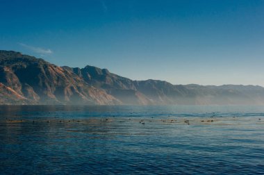 Atitlan Gölü 'ndeki Atitlan Toliman adlı iki volkanın sabah ışığı.
