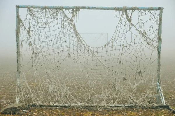 古い空の放棄されたサッカー場と光霧の中で絡んだ網でゲート — ストック写真